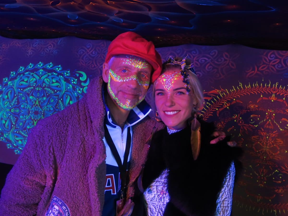 UV-valguses festivaliala, kaks külalist UV-näomaalinguga